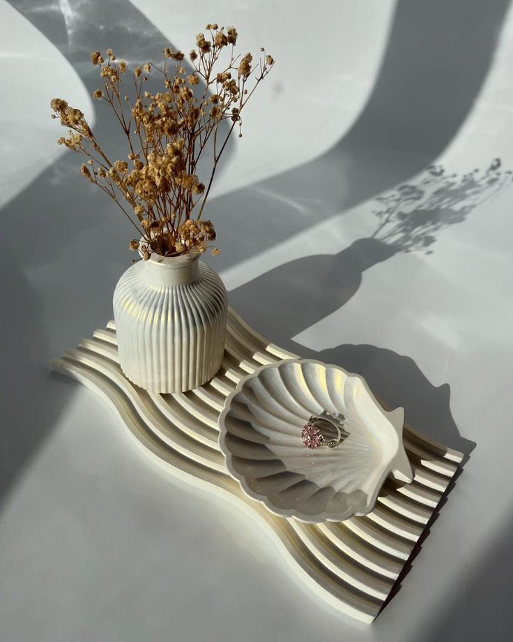 Pearlescent white wavy tray with scalloped seashell jewelry dish holding ring and fluted mini vase