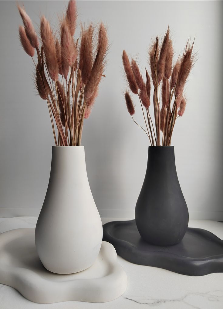 Matte black and white droplet vases on organic clay trays