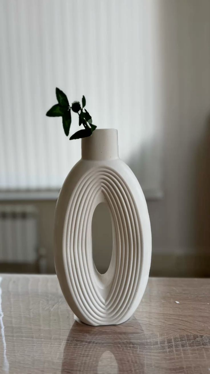 Tall oval hollow sculptural ceramic vase with concentric ribbed ridges
