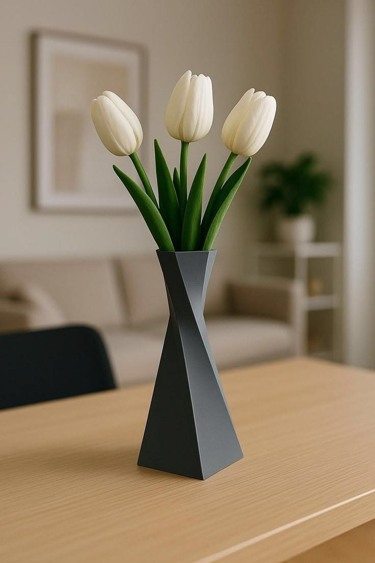 Geometric matte black spiral twist vase on blonde wood table with white tulips